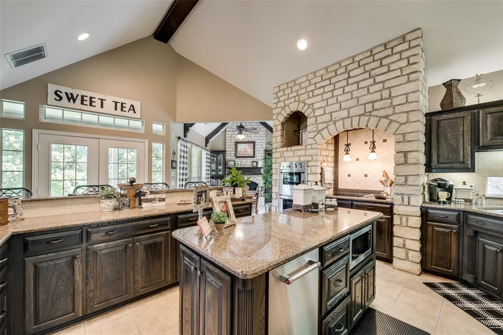 3325 Creek Road Keller, TX 76248 - Photo 22 of 28 a kitchen with stainless steel appliances granite countertop a sink a stove and a wooden cabinets
