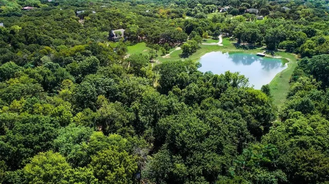 an aerial view of a house with a yard and lake view