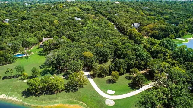 an aerial view of residential house with outdoor space and trees all around