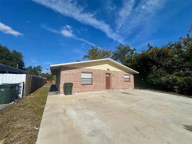 a view of house with yard and trees in the background