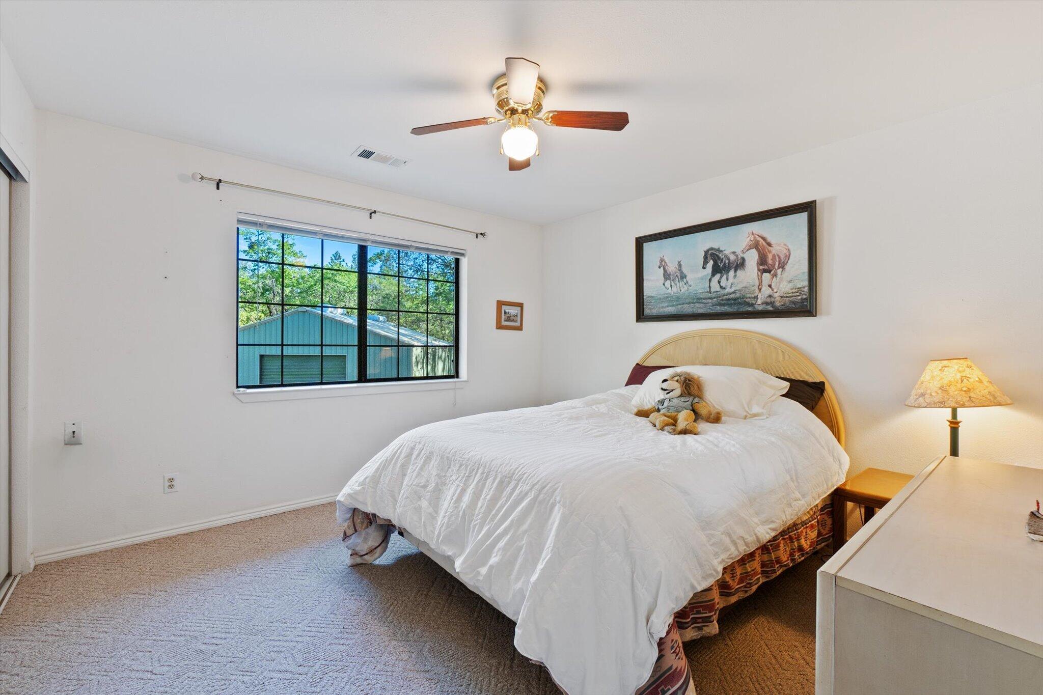 26997 Lookout Mountain Road Oak Run, CA 96069 - Photo 38 of 92 a bedroom with a bed and a chandelier