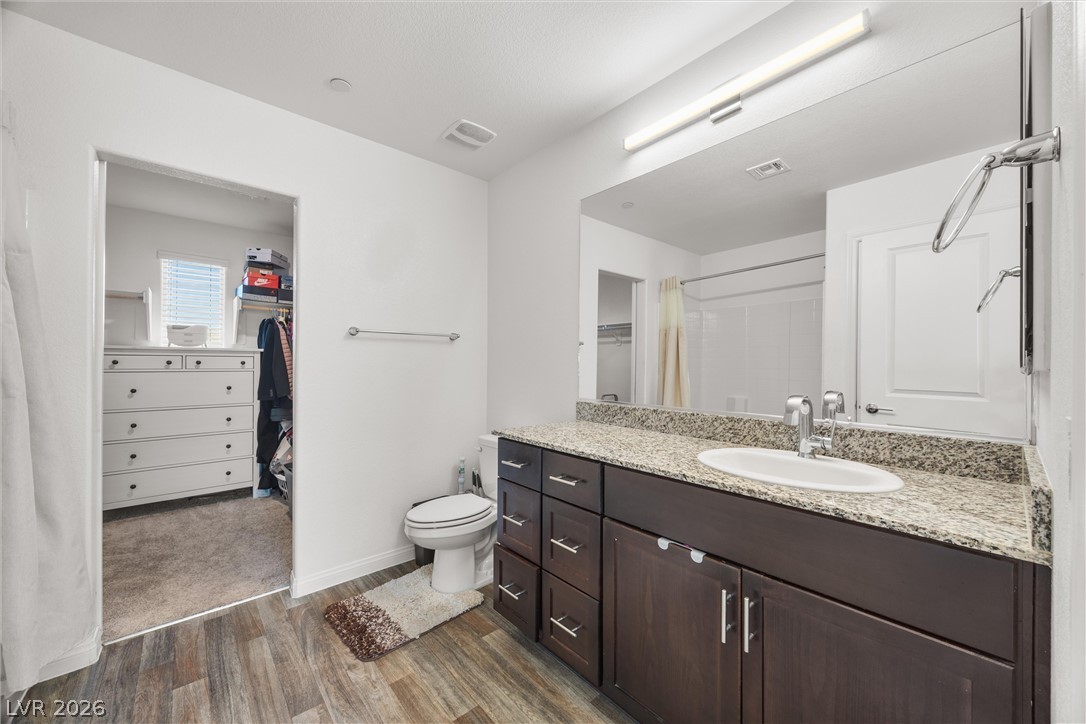 12240 Golden Wreath Road, Unit 2 Las Vegas, NV 89183 - Photo 16 of 29 Rich stone counters highlight the modern vanity adjacent to a spacious walk-in closet.