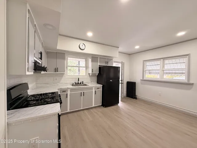 a kitchen with stainless steel appliances granite countertop a refrigerator and a stove top oven