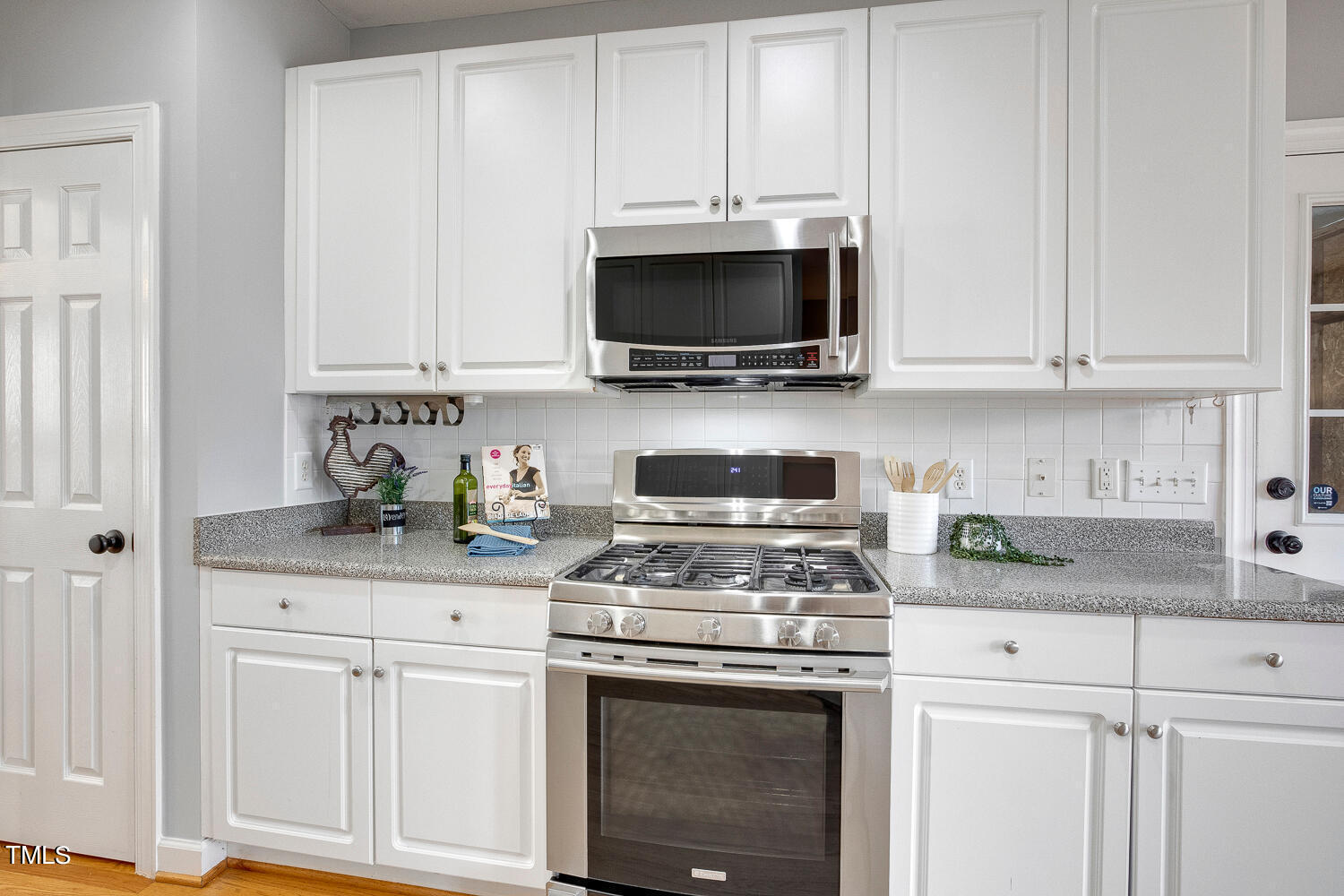 6324 Nowell Pointe Drive Raleigh, NC 27607 - Photo 12 of 50 a kitchen with stainless steel appliances granite countertop grey cabinets a stove and a sink