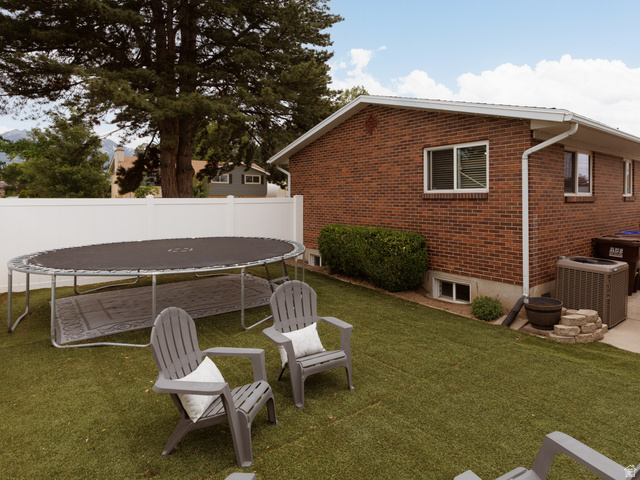 8252 Wood Street Midvale, UT 84047 - Photo 25 of 40 Private backyard featuring artificial turf, a white vinyl fence, and a mature tree