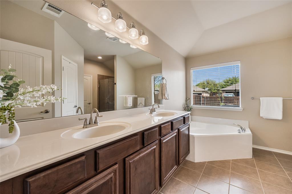 1260 Highbluff Lane Rockwall, TX 75087 - Photo 14 of 22 a bathroom with a sink a large mirror and a bathtub