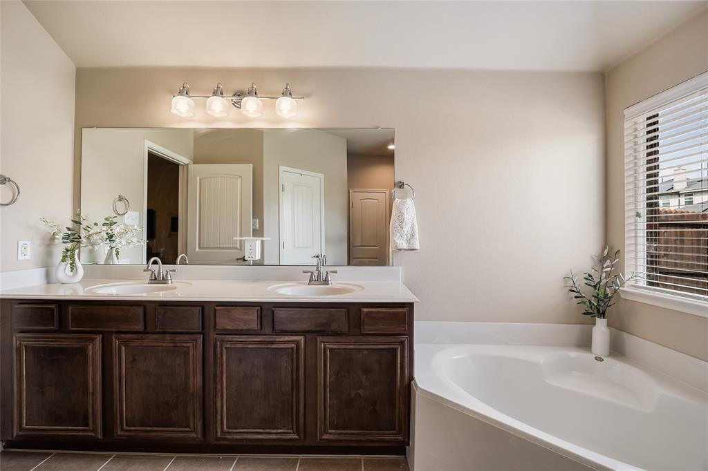 1260 Highbluff Lane Rockwall, TX 75087 - Photo 15 of 22 a bathroom with a double vanity sink and a bathtub