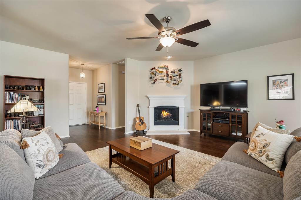 1260 Highbluff Lane Rockwall, TX 75087 - Photo 7 of 22 a living room with furniture a flat screen tv and a fireplace
