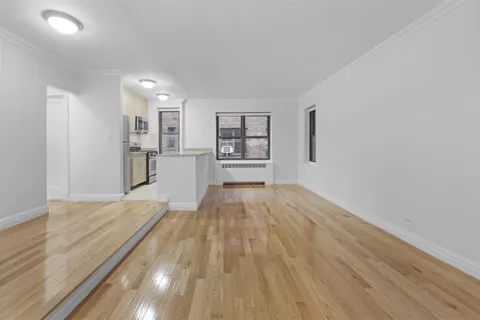 a view of empty room with wooden floor