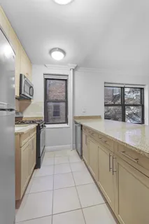 a large white kitchen with granite countertop a sink a stove a washer and dryer