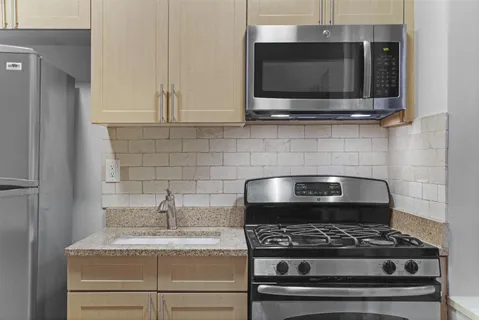 a kitchen with granite countertop a stove and a microwave