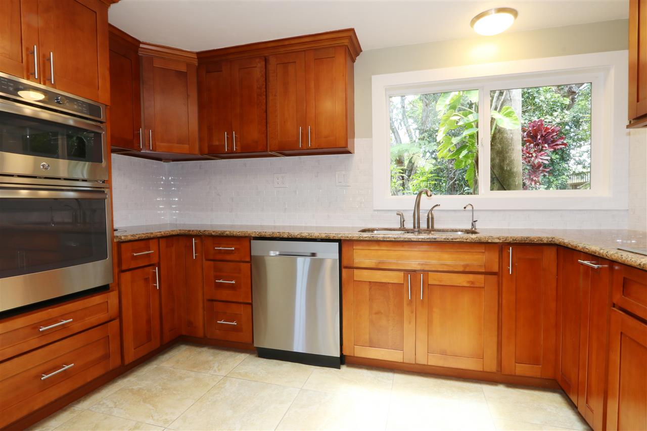 620 Awalau Road Haiku, HI 96708 - Photo 15 of 30 a kitchen with stainless steel appliances granite countertop wooden cabinets a stove a sink and dishwasher