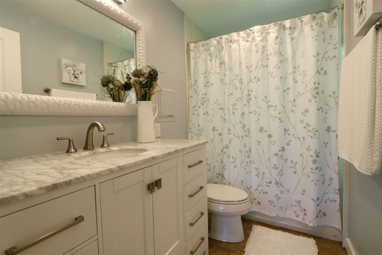 620 Awalau Road Haiku, HI 96708 - Photo 18 of 30 a bathroom with a granite countertop sink a toilet and a mirror