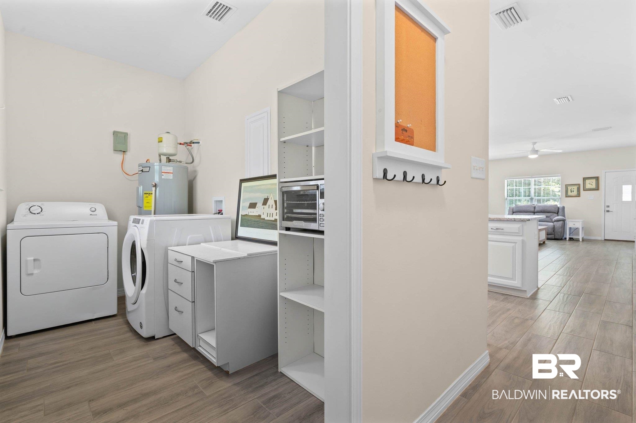 13751 Fish River Acres Circle Foley, AL 36535 - Photo 20 of 26 Dedicated utility area featuring wood-finish flooring, a water heater, and built-in shelving