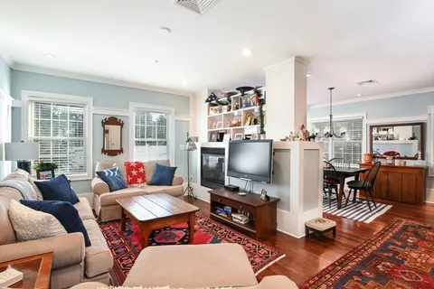 a living room with furniture a rug and a flat screen tv