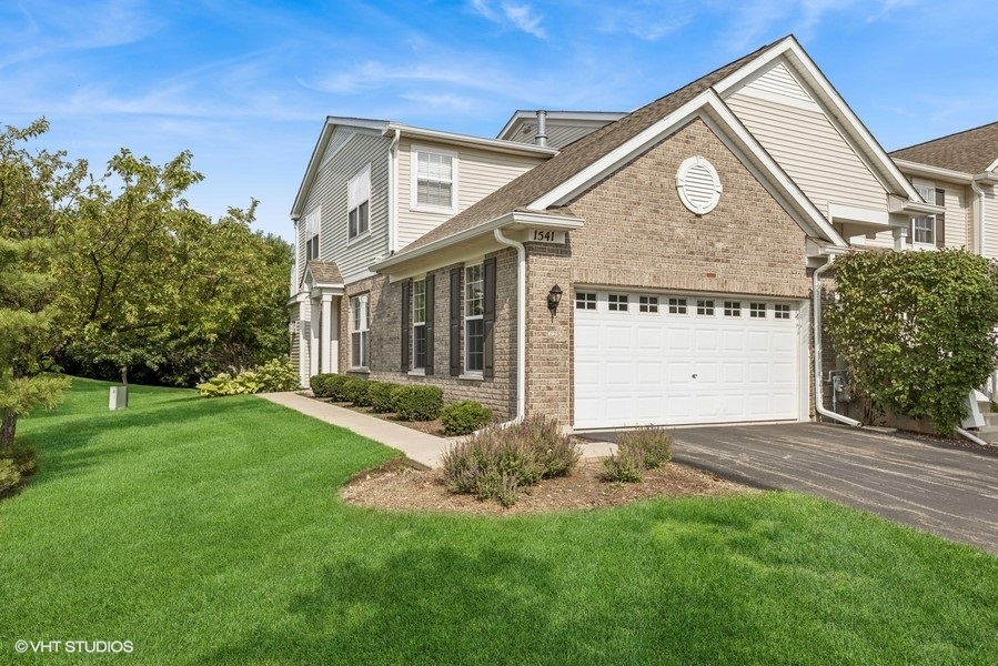a front view of a house with a yard and garage