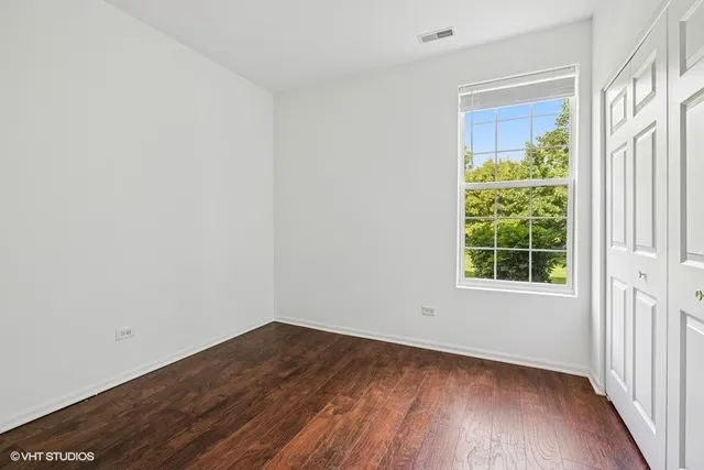 a view of a room that has wooden floor and a window