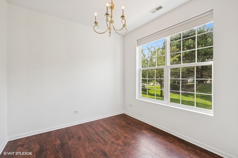 1541 Millbrook Drive, Unit 1541 Algonquin, IL 60102 - Photo 6 of 17 a view of an empty room with wooden floor and windows