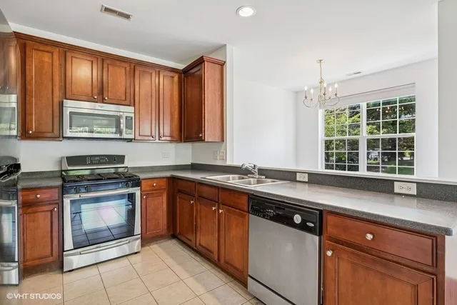 a kitchen with stainless steel appliances granite countertop a stove sink and cabinets
