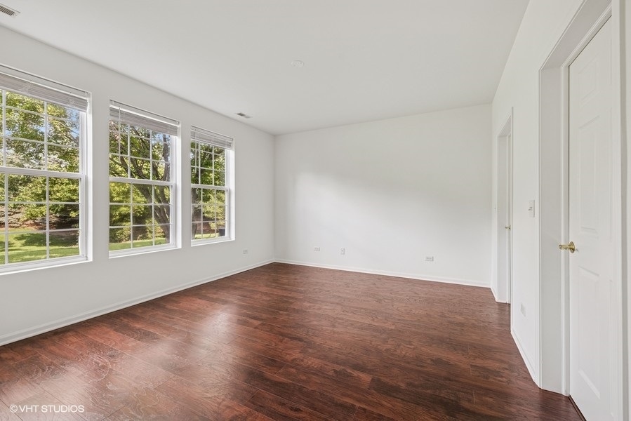 1541 Millbrook Drive, Unit 1541 Algonquin, IL 60102 - Photo 10 of 17 an empty room with wooden floor and windows