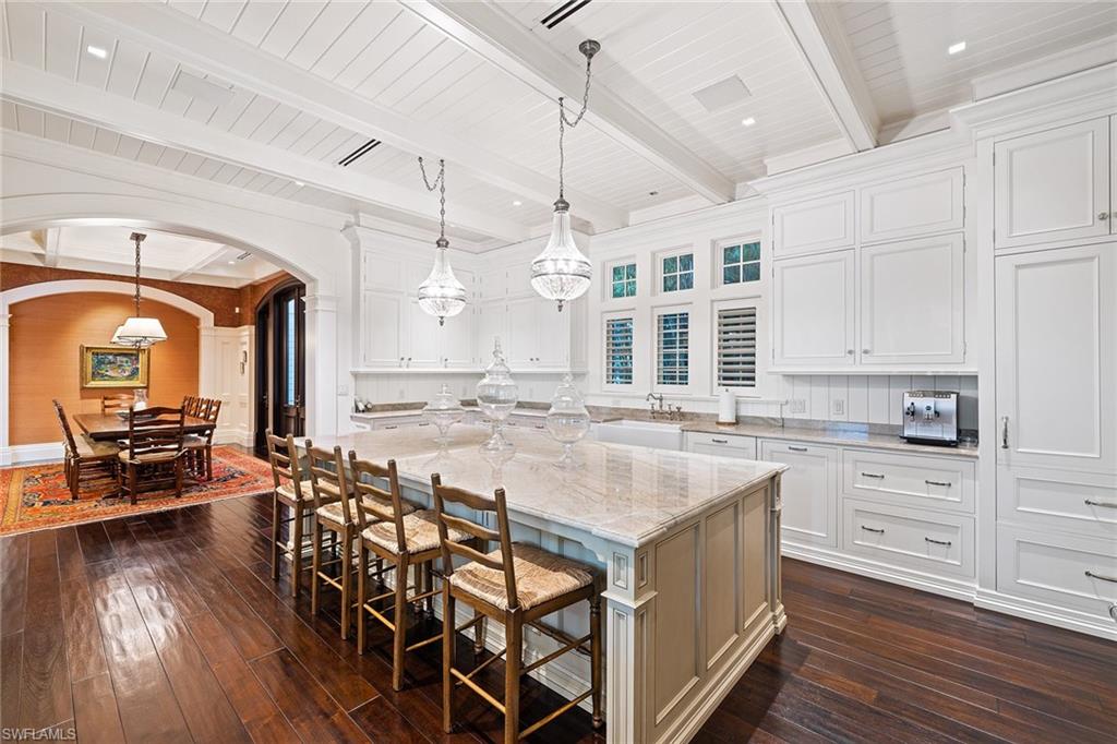 163 10th Avenue South Naples, FL 34102 - Photo 11 of 50 a kitchen with stainless steel appliances granite countertop a kitchen island a stove a table and chairs in it