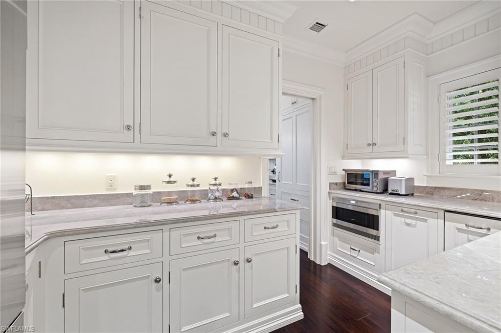 163 10th Avenue South Naples, FL 34102 - Photo 18 of 50 a kitchen with granite countertop white cabinets and white appliances