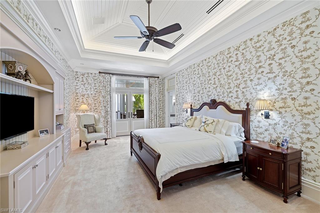 163 10th Avenue South Naples, FL 34102 - Photo 20 of 50 a spacious bedroom with a bed and a flat screen tv