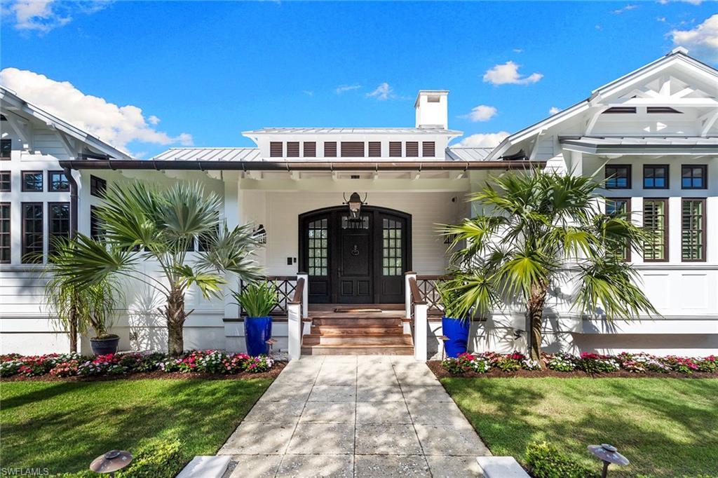 163 10th Avenue South Naples, FL 34102 - Photo 2 of 50 a front view of a house with garden