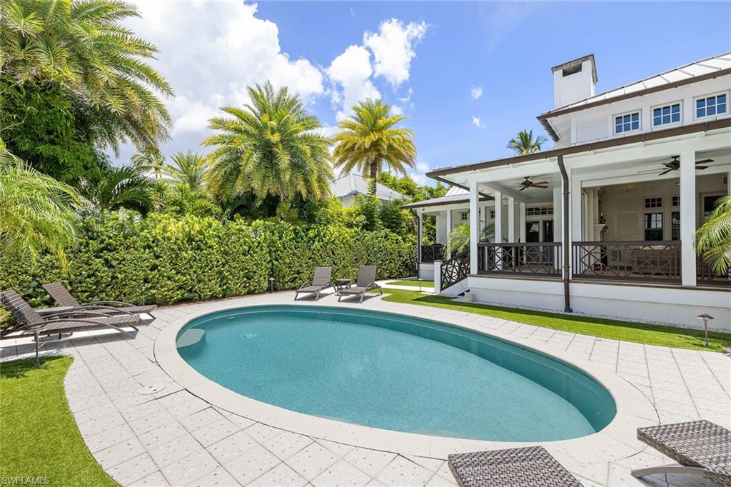 163 10th Avenue South Naples, FL 34102 - Photo 50 of 50 a view of swimming pool with outdoor seating and house in the background