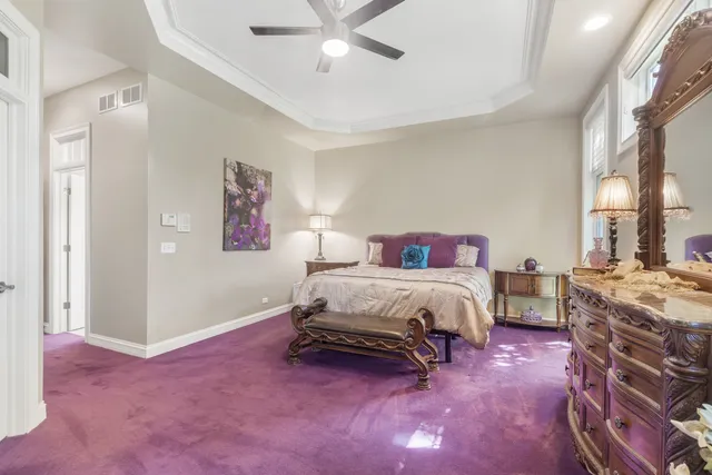 a spacious bedroom with a bed and a chandelier