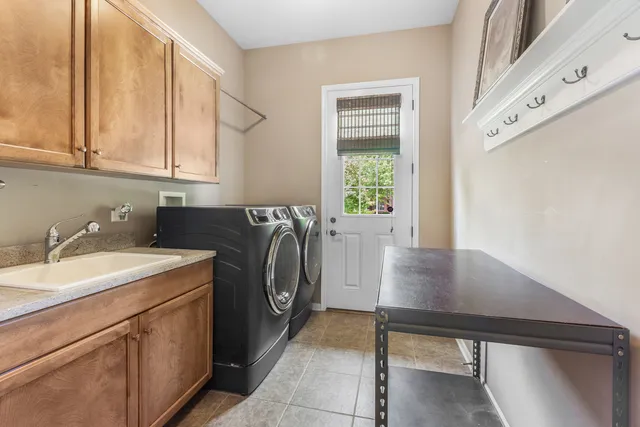 a utility room with sink dryer and washer