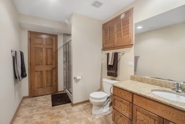 a bathroom with a granite countertop sink toilet and shower