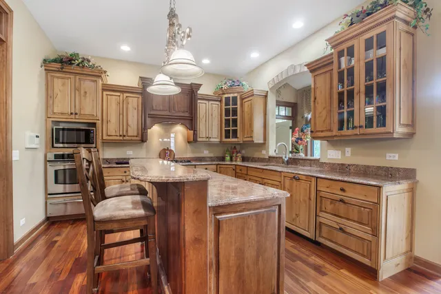 a kitchen with cabinets a sink appliances and wooden floor
