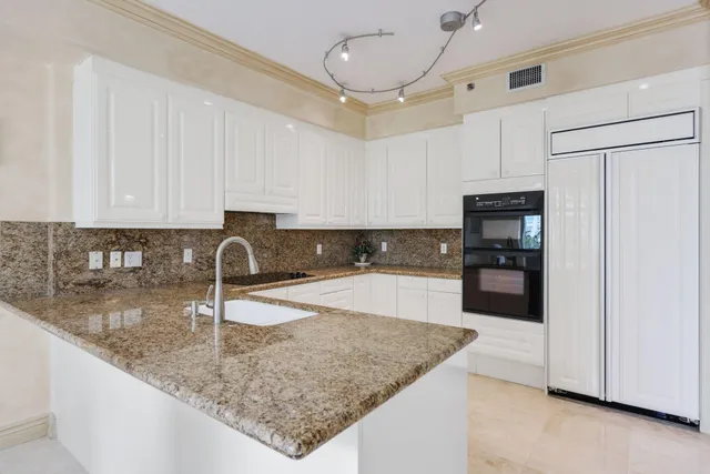 a large white bathroom with a large tub sink vanity granite and a large mirror