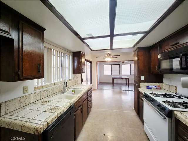 a kitchen with granite countertop a sink stove and cabinets