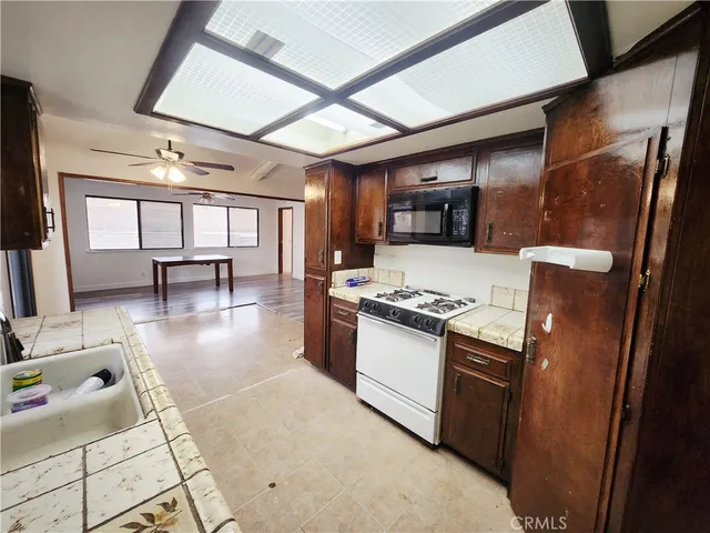 a kitchen with granite countertop a sink stove and cabinets