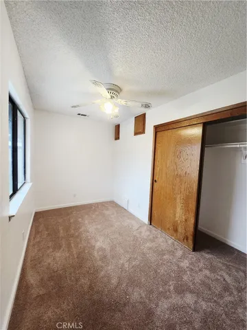 an empty room with windows and closet