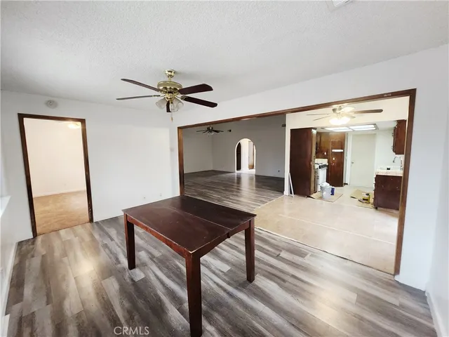a living room with a table chairs and a wooden floor