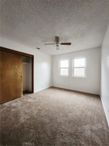 an empty room with windows and closet