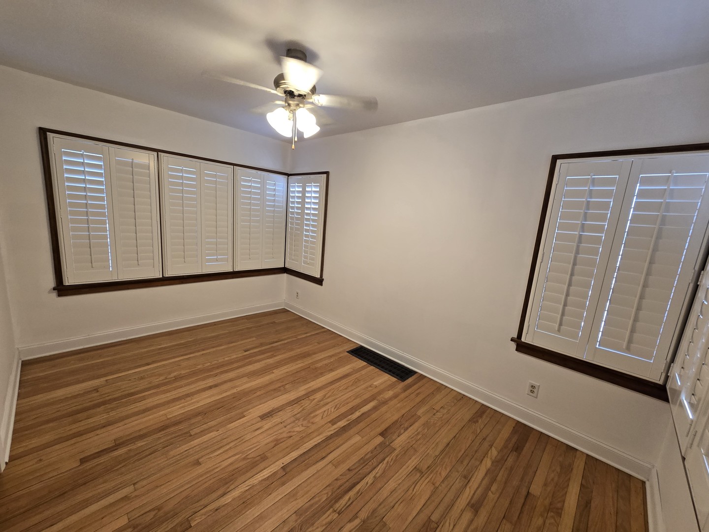 310 Genoa Road Genoa, IL 60135 - Photo 3 of 7 a view of an empty room with wooden floor and fan