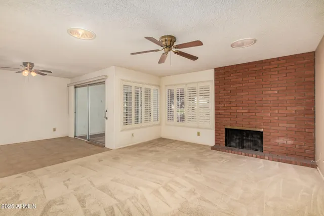 a view of an empty room with a fireplace and a window