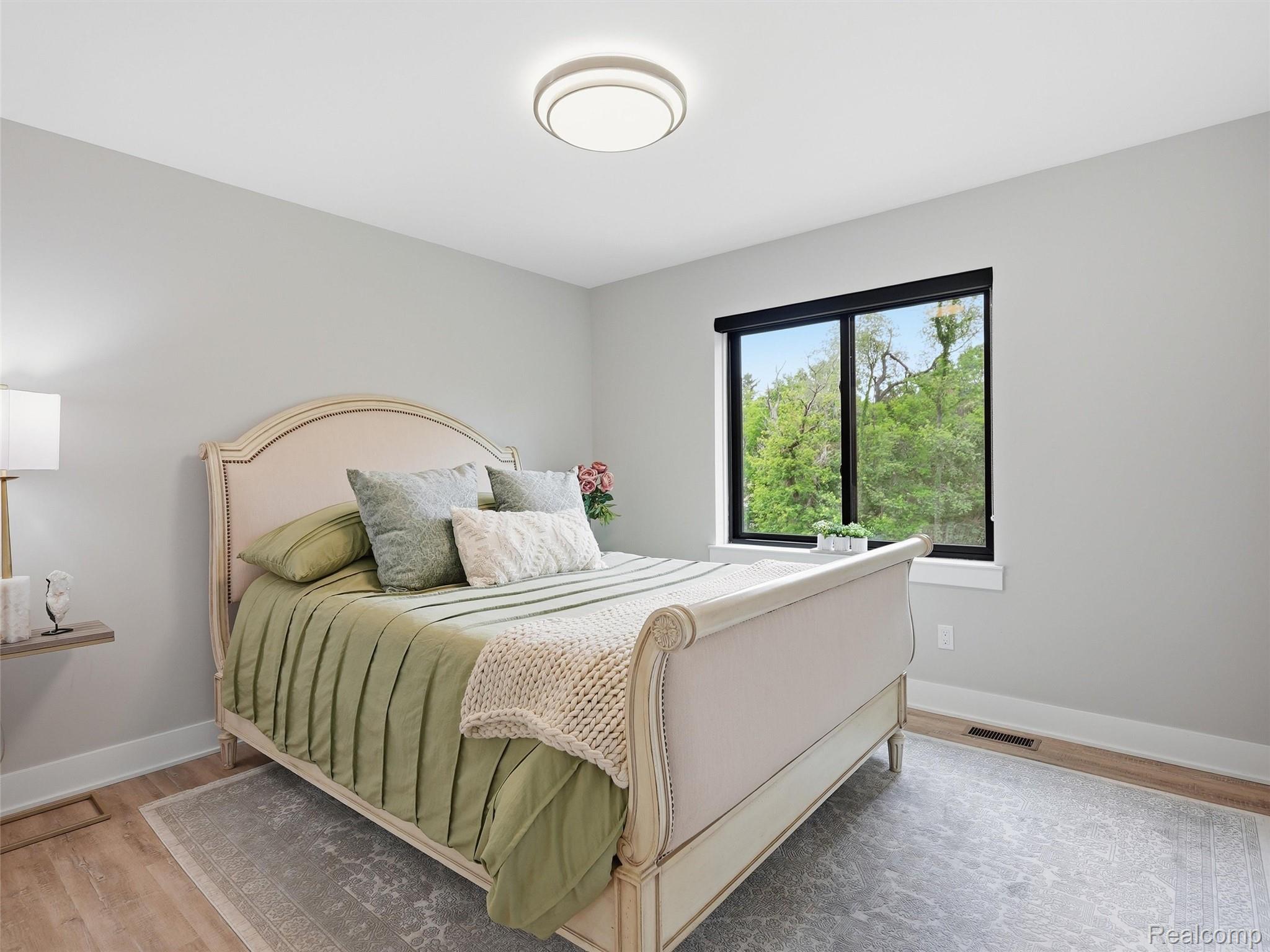 3007 28 Mile Road Washington, MI 48094 - Photo 35 of 69 Light-filled room featuring wood-finish flooring, light gray walls, a flush-mount ceiling light, and a large window with a black frame