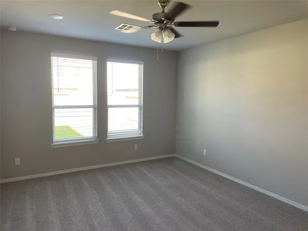 an empty room with a window and a fan