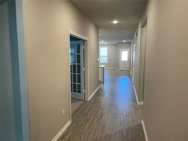 a view of a hallway with wooden floor