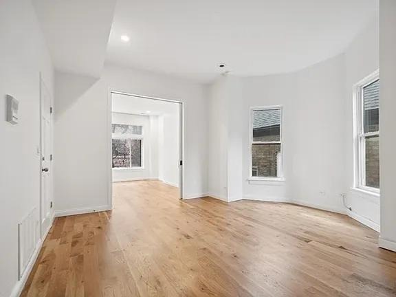 446 North Aberdeen Street, Unit 2 Chicago, IL 60642 - Photo 2 of 12 wooden floor in an empty room with a window