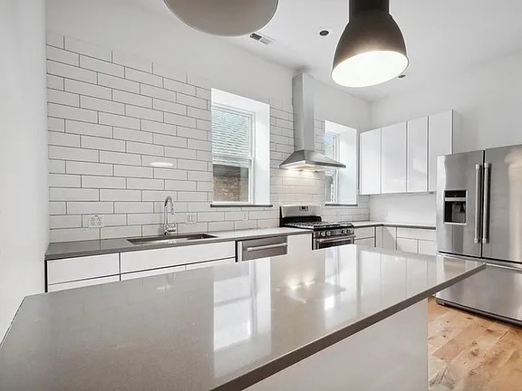 446 North Aberdeen Street, Unit 2 Chicago, IL 60642 - Photo 3 of 12 a kitchen with stainless steel appliances granite countertop a sink a stove and a refrigerator