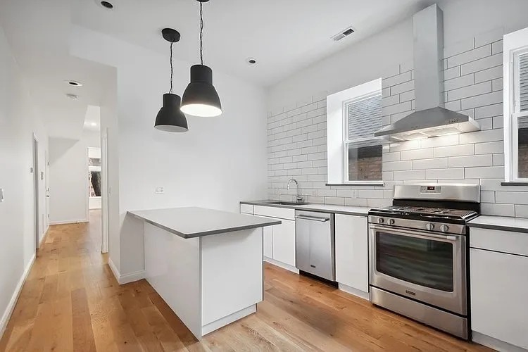 446 North Aberdeen Street, Unit 2 Chicago, IL 60642 - Photo 4 of 12 a kitchen with stainless steel appliances granite countertop a stove and a sink