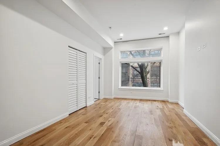 446 North Aberdeen Street, Unit 2 Chicago, IL 60642 - Photo 7 of 12 an empty room with wooden floor and windows