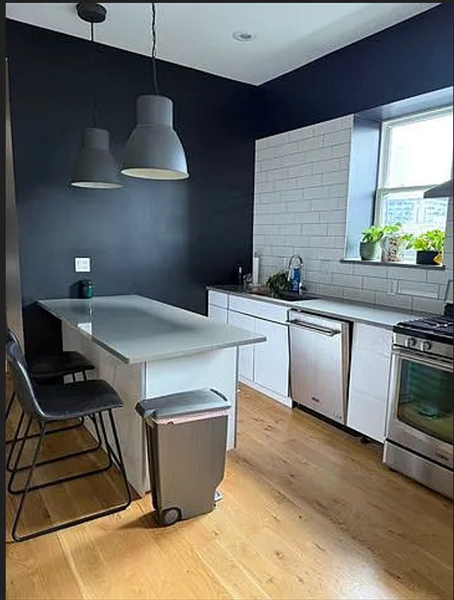 446 North Aberdeen Street, Unit 2 Chicago, IL 60642 - Photo 9 of 12 a kitchen with stainless steel appliances a stove a sink a counter space and cabinets