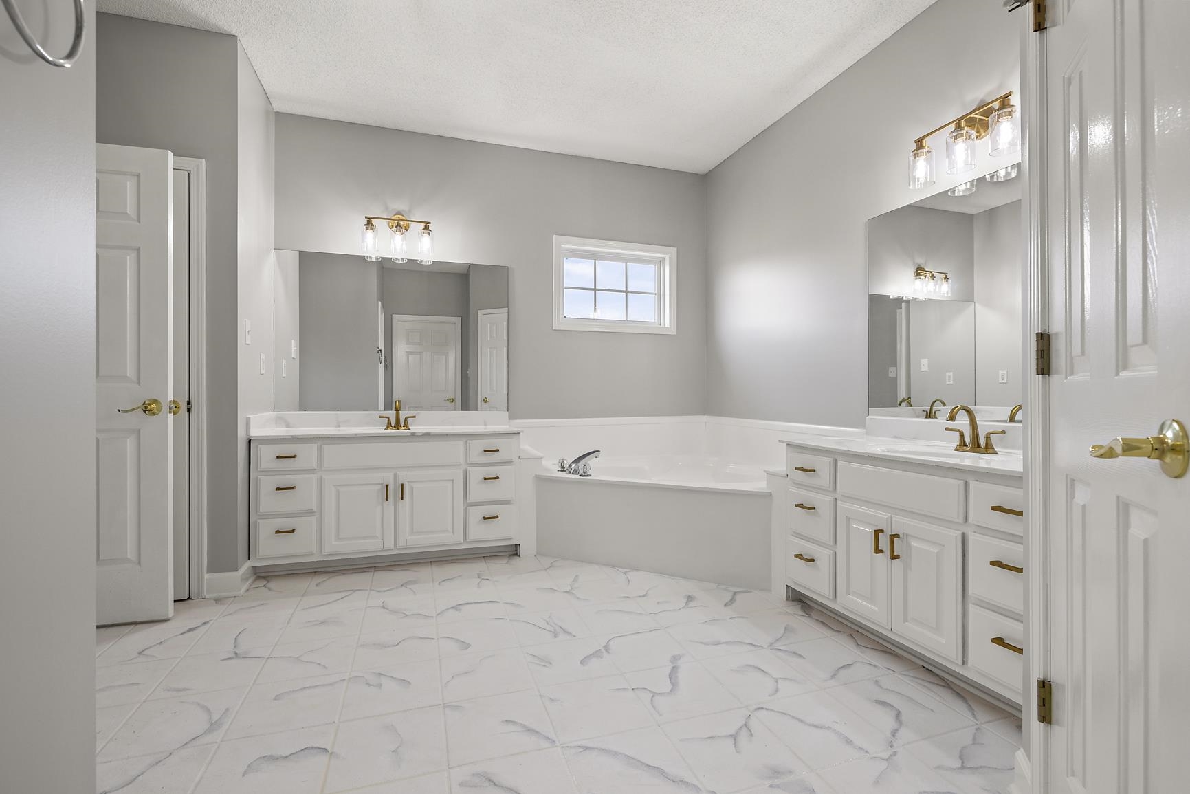 369 Rosemark Road Atoka, TN 38004 - Photo 13 of 27 a spacious bathroom with a double vanity sink a mirror a bathtub and a shower
